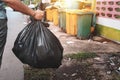 woman hand holding garbage in black bag for cleaning in to trash Royalty Free Stock Photo