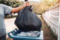 woman hand holding garbage in black bag for cleaning in to trash Royalty Free Stock Photo