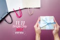 Woman hand holding gift box and shopping bag for 11.11 single day sale Royalty Free Stock Photo