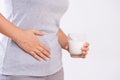 Woman hand holding glass of milk having bad stomach ache because of Lactose intolerance. health problem with dairy food products, Royalty Free Stock Photo