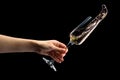 Woman hand holding glass of sparkling champagne with splashes isolated on black. Royalty Free Stock Photo