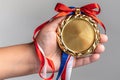 woman hand, holding gold medal on white background Royalty Free Stock Photo