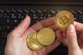 Woman hand holding golden coloured bitcoin and eos crytpocurrency coins over black laptop keyboard Royalty Free Stock Photo