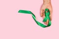 Woman hand holding a green ribbon