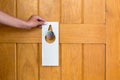 Woman hand holding and hangs signboard do not disturb on the door in hotel