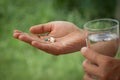 Woman hand holding heap of pills and water glass Royalty Free Stock Photo