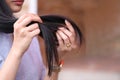 Woman hand holding her long hair with looking at damaged splitting ends of hair care problems Royalty Free Stock Photo