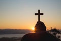 Woman hand holding holy lift of christian cross with light sunset background Royalty Free Stock Photo