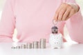 Woman hand holding house keychain with stack of coins Royalty Free Stock Photo