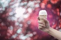 A woman hand holding Ice cream cone with abstract bokeh background,filtered image,colorful picture style