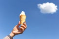 Woman hand holding ice cream cone with blue sky background Royalty Free Stock Photo