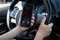 Woman hand holding iPhone with Widgets call IOS14 the car