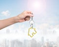 Woman hand holding key with house shape keyring Royalty Free Stock Photo