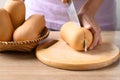 Woman hand holding kitchen knife and cutting butternut squash