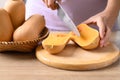 Woman hand holding kitchen knife and cutting butternut squash