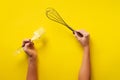 Woman hand holding kitchen utensils on yellow background. Baking tools - brush, whisk, spatula. Bakery, cooking, healthy homemade Royalty Free Stock Photo