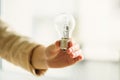 Woman hand holding light bulb on cream background with copy space. Creative idea, new business plan, motivation Royalty Free Stock Photo