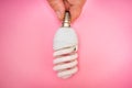 Woman hand holding light bulb on pink background Royalty Free Stock Photo
