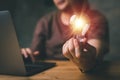 Woman hand holding light bulb and using laptop on wooden table. new idea creativity concept with innovation and inspiration. Royalty Free Stock Photo