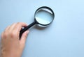 Woman hand holding  Magnifying glass  isolate on a blue backgroun Royalty Free Stock Photo