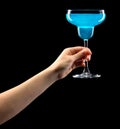 Woman hand holding margarita glass isolated on black.