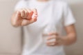 woman hand holding medicine painkiller pill and water glass on the sofa at home, taking for headaches, stomach ache, Diarrhea Royalty Free Stock Photo