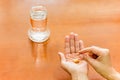 Woman hand holding medicine pills with glass of water. Royalty Free Stock Photo