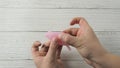 Woman hand holding menstrual cup and demonstrating labia folding methods