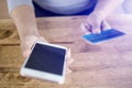 Woman hand holding mobile phone and credit card to paying product in website online shopping on the wooden table