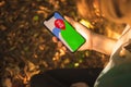 Woman hand holding mobile phone with the map in the forest, outdoor navigation with modern smartphone, concept of Royalty Free Stock Photo