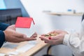 Woman hand holding money with man hand house model Royalty Free Stock Photo