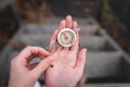 Woman hand holding a old compass with broken glass and ladybug. Travel concept, path selection, navigation, tourism, hiking. Royalty Free Stock Photo