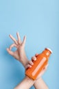 Woman hand holding orange detox drink and showing ok sign Royalty Free Stock Photo