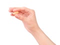 Woman hand holding orange pill Royalty Free Stock Photo