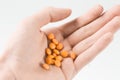 Woman hand holding orange pills before doing suicide Royalty Free Stock Photo