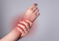 Woman hand holding painful wrist with red spot closeup. Health problems, injury, fatigue, overwork, office syndrome