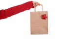 Woman hand holding papper bag with red ribbon