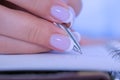 Woman hand holding pen and writing to do list in vintage notebook organizer Royalty Free Stock Photo