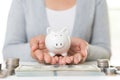 Woman hand holding piggy bank with stack of coins Royalty Free Stock Photo