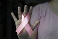 Woman hand holding pink breast cancer awareness ribbon. Royalty Free Stock Photo