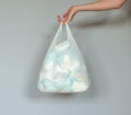 Woman hand holding a plastic bag full of dirty used baby diapers Royalty Free Stock Photo