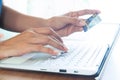 Woman hand holding plastic credit card and using laptop computer. Online shopping, paying, buying, e-payment and technology Royalty Free Stock Photo