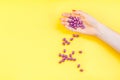 Woman hand holding purple pills handful