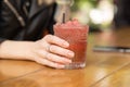 Woman hand holding red cocktail glass with ice. Royalty Free Stock Photo