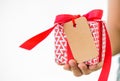 Woman hand holding a red gift box with tags card copy space Royalty Free Stock Photo