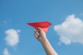 Woman hand holding a red paper rocket with a bright blue background Royalty Free Stock Photo