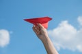 Woman hand holding a red paper rocket with a bright blue background Royalty Free Stock Photo