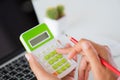 Woman hand holding red pencil and working with calculator Royalty Free Stock Photo