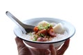 Woman hand holding rice porridge with pork and Fried Chinese sausage in white bowl isolated on white background Royalty Free Stock Photo