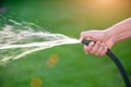 Woman hand holding rubber water hose